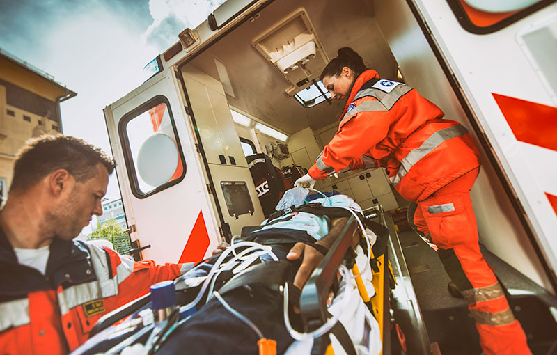 Notfallteam lädt einen Patienten in einen Krankenwagen ein.